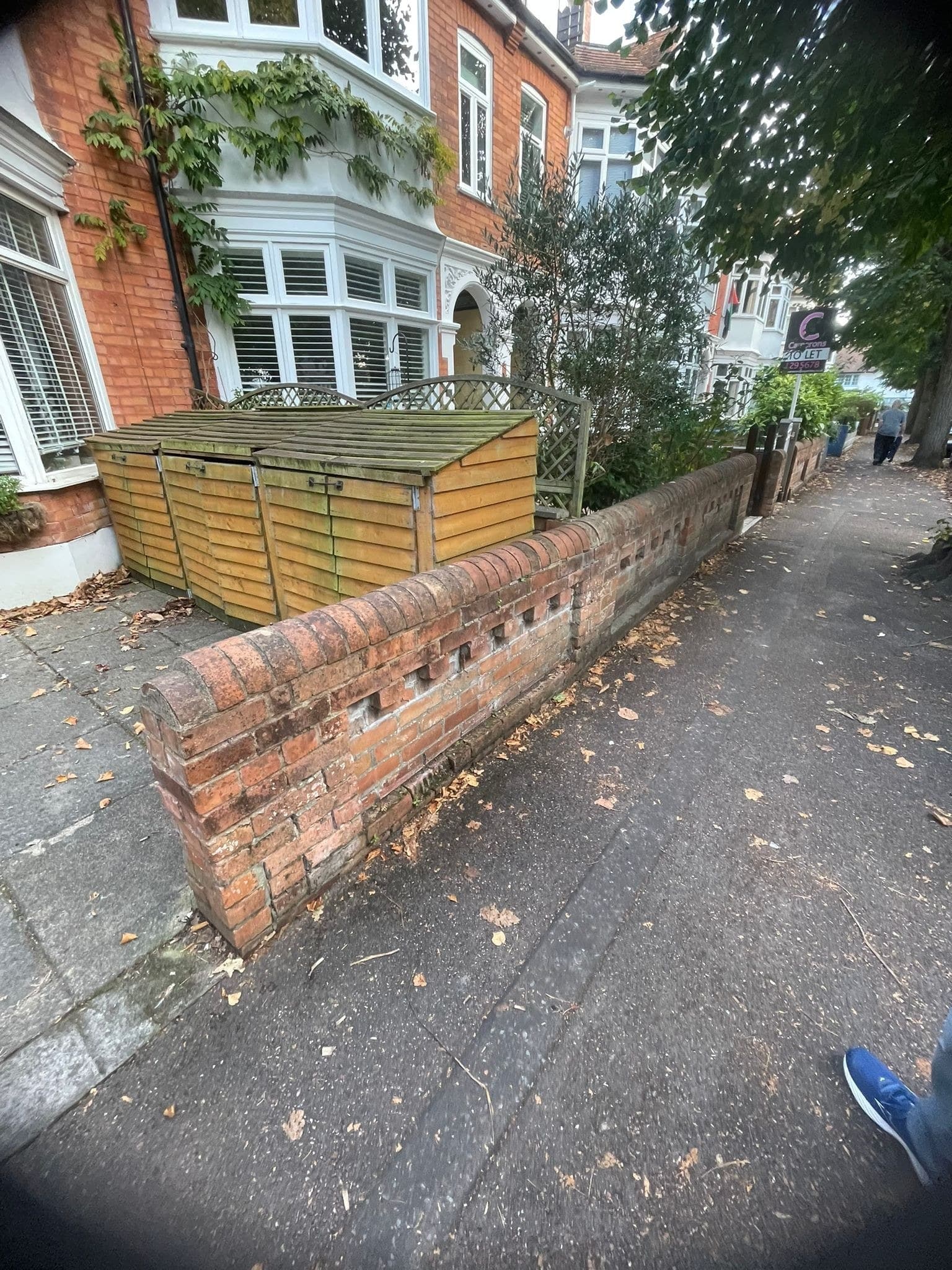 A weathered front wall with an eroded dentil course, before repointing