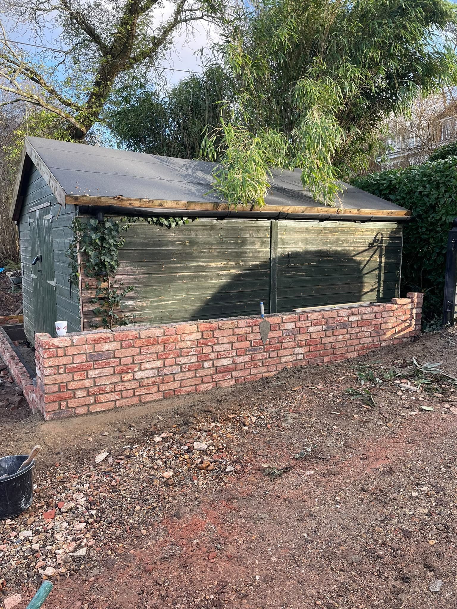 A new low red brick garden wall along a boundary