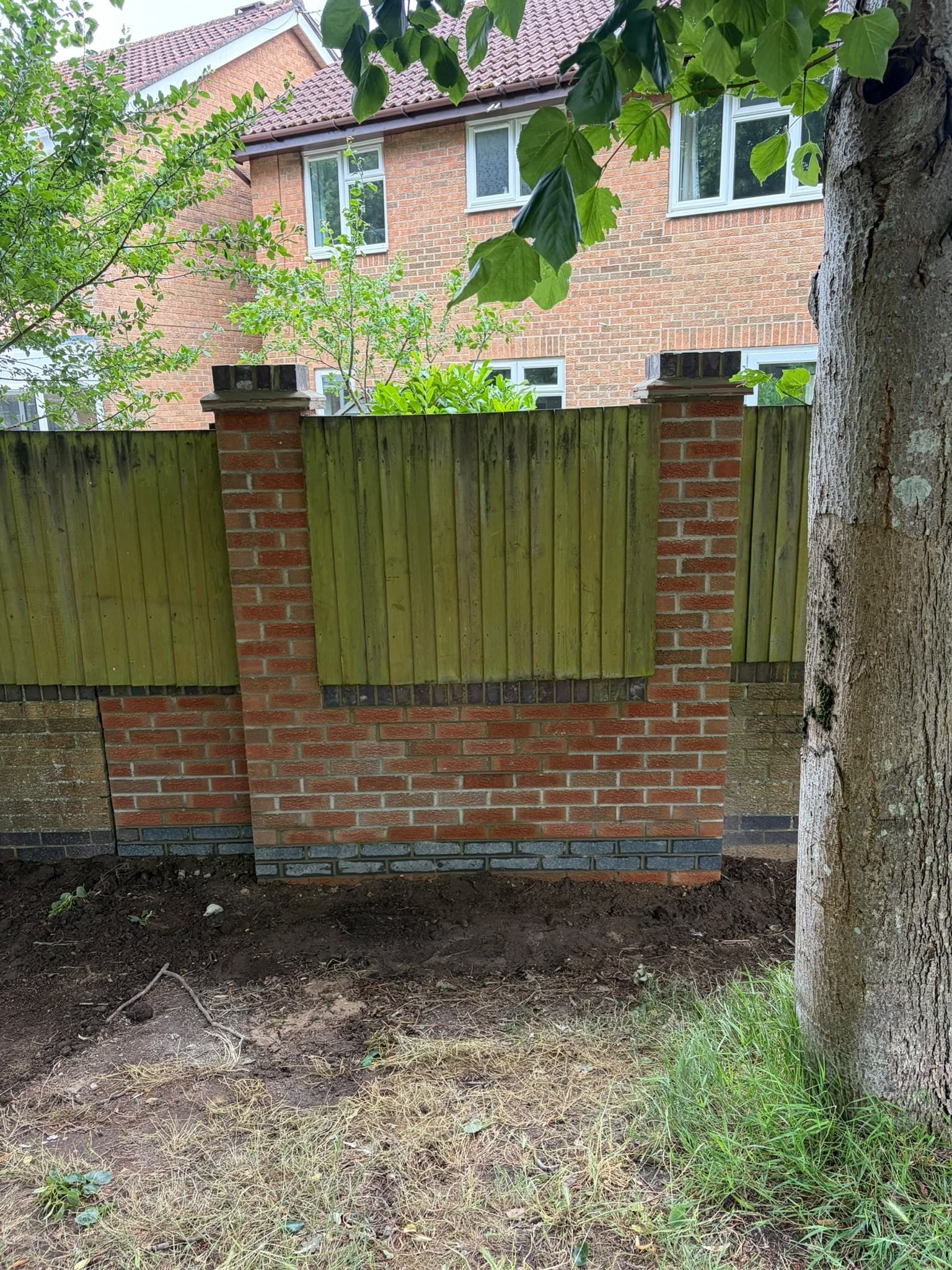 Brick piers built between fence panels along a garden boundary