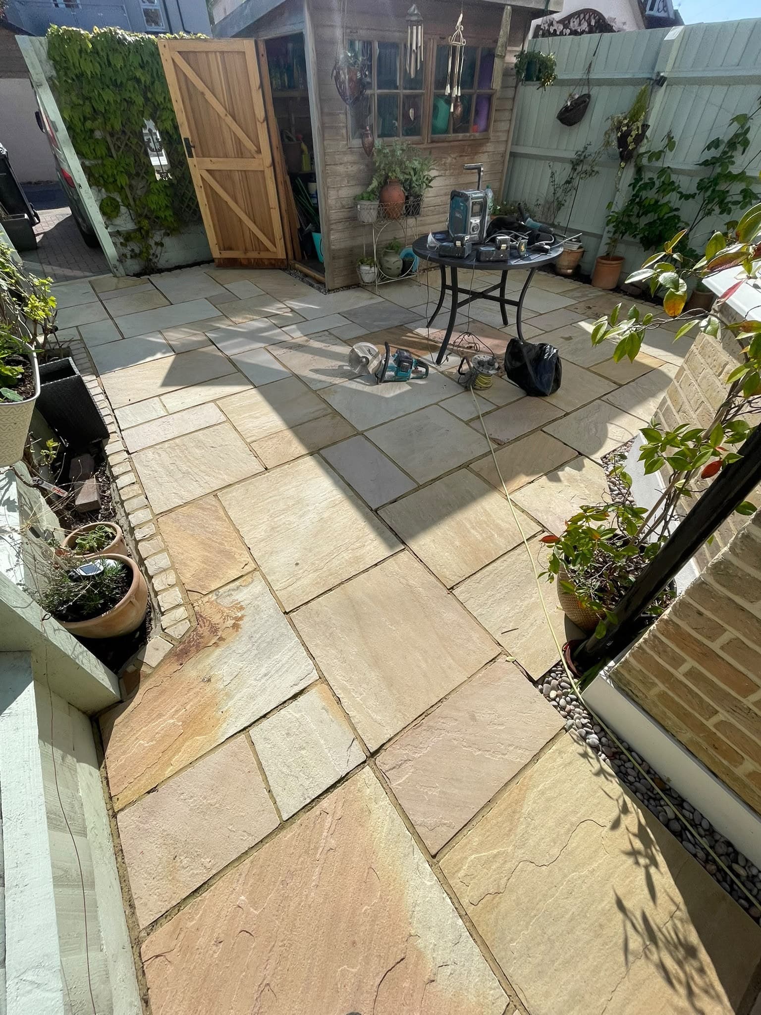 Buff sandstone paving run up to a garden store