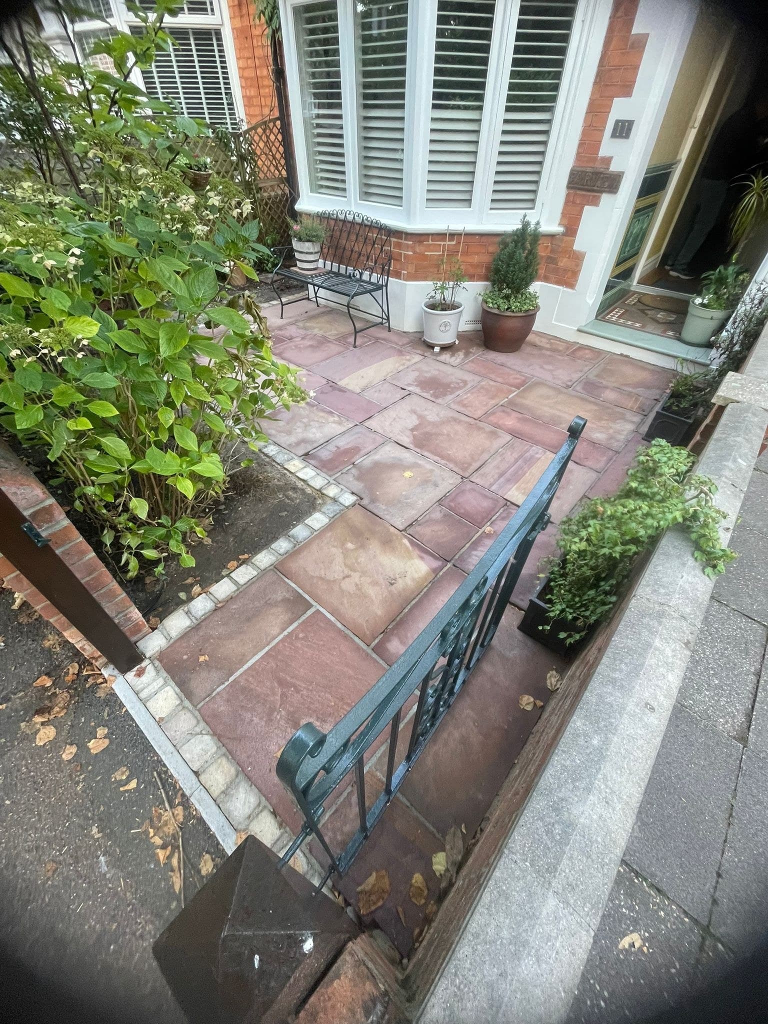 An Indian sandstone path alongside a bay-fronted house