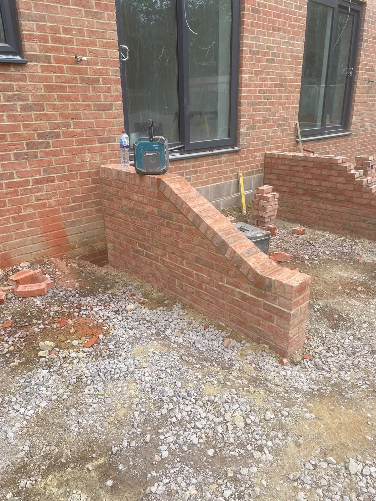Brick steps part built, with the retaining brickwork rising